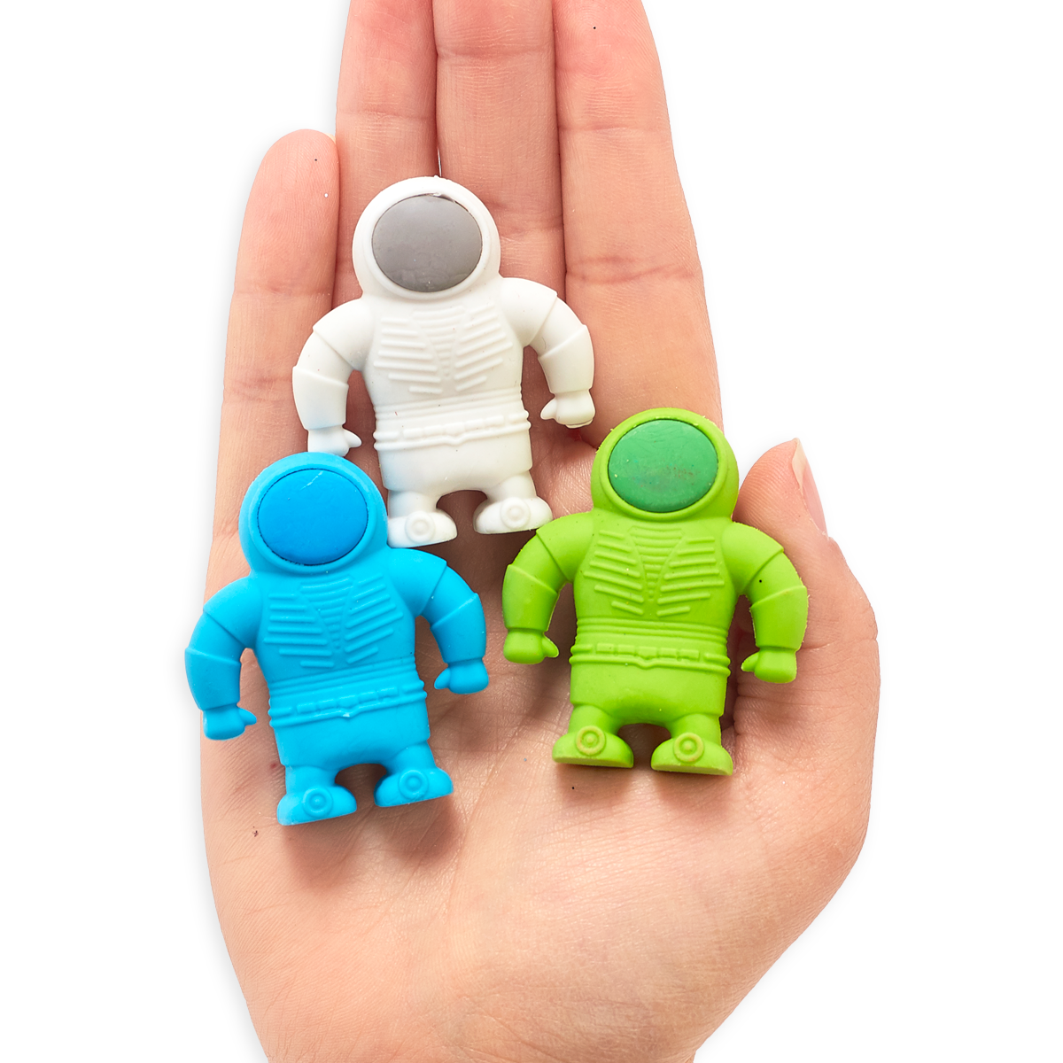 Blue, white and green astronaut erasers in the palm of a hand