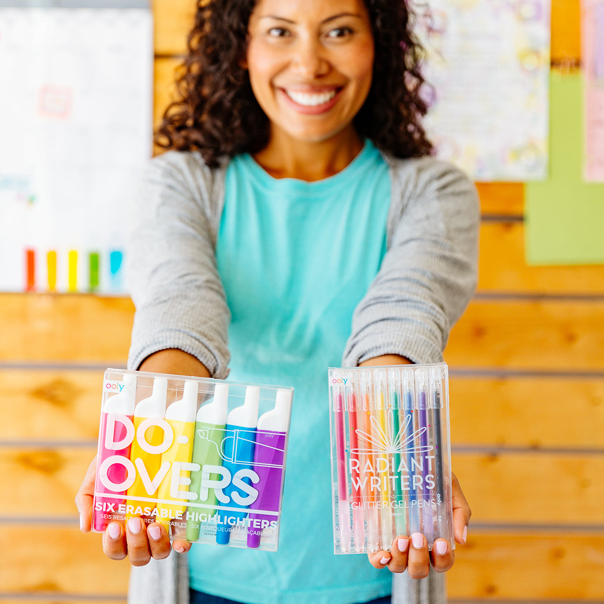 Happy teacher holding up radiant writers and do-overs highlighters