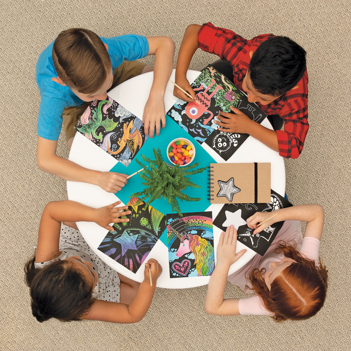 Group of kids at a table with Scratch and Scribble scratch art kits