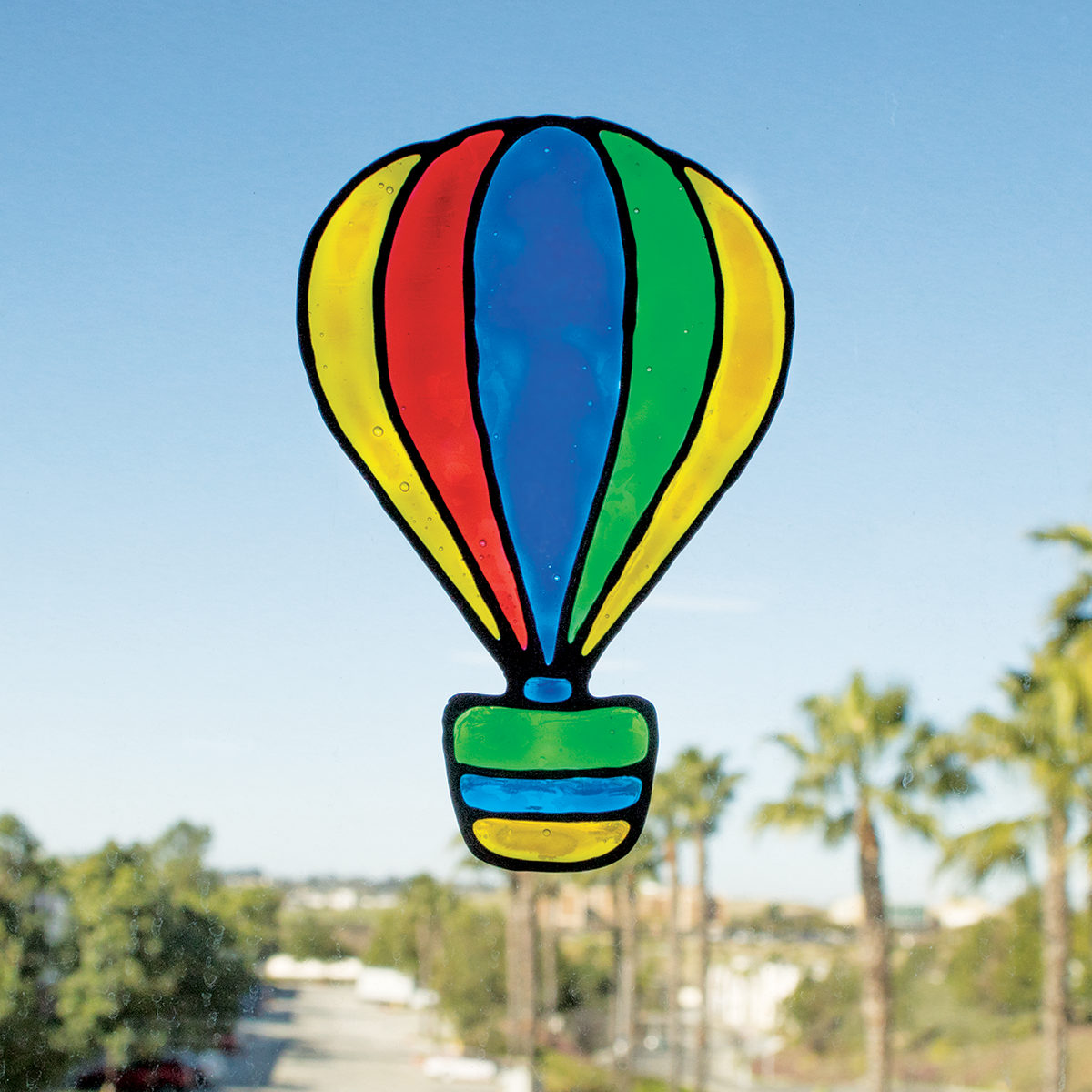 Colorful hot air balloon window cling on a window made from Creatibles DIY Window Cling art kit