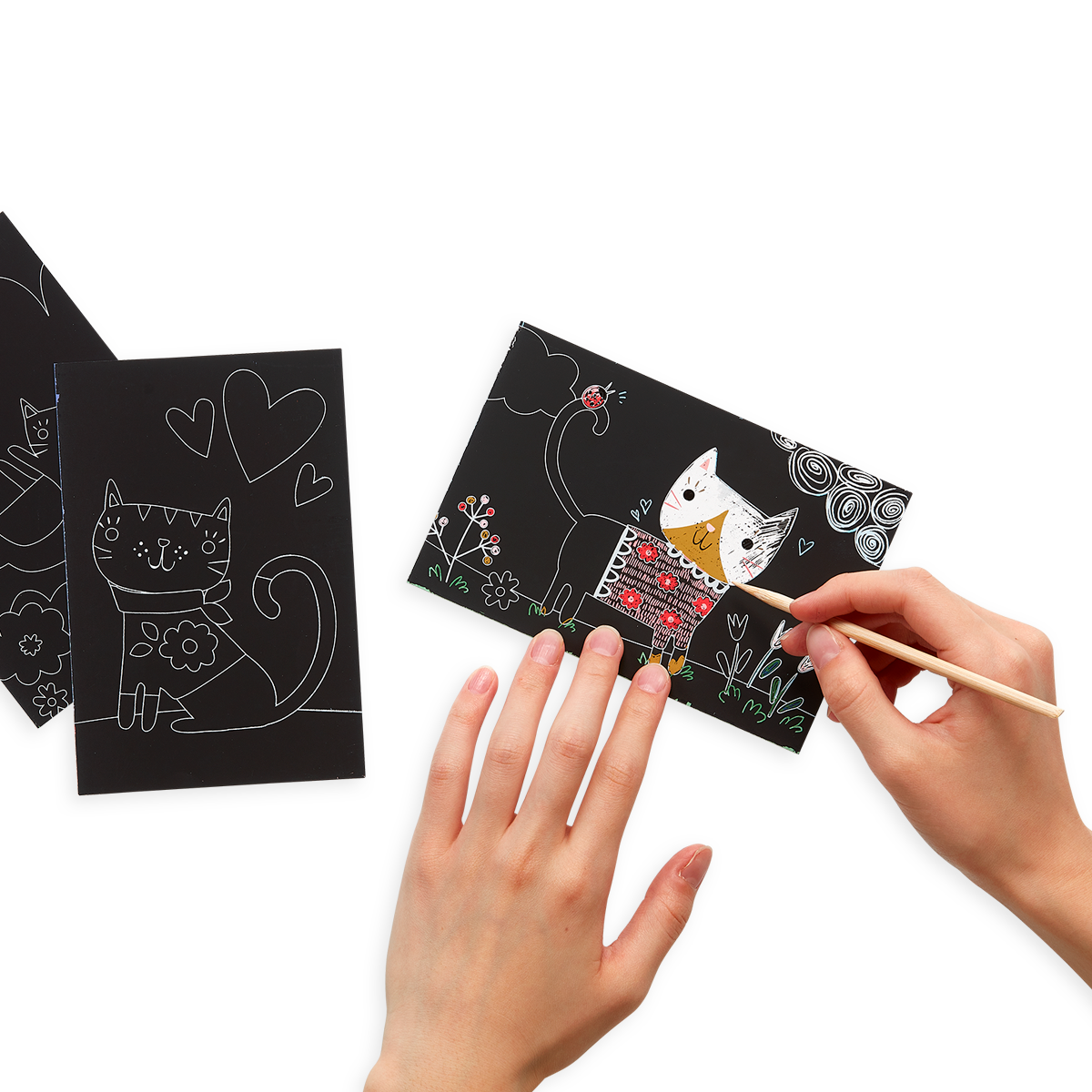 Lifestyle image of person using the Cutie Cats Scratch and Scribble Mini Scratch Art Kit