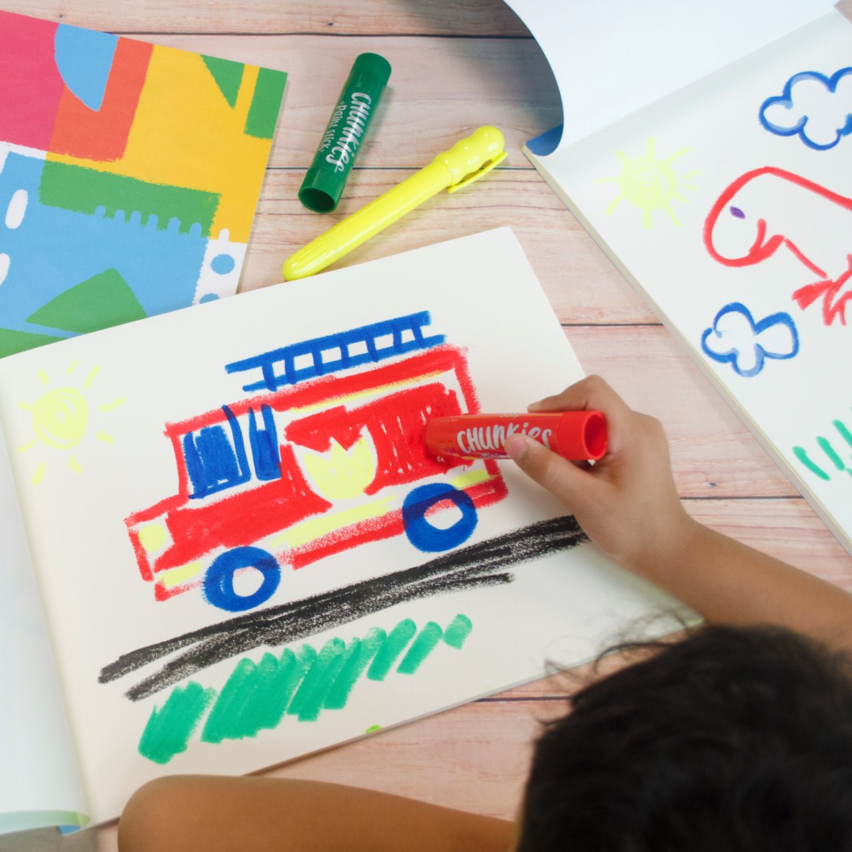 Kid painting fire truck with Chunkies Paint Sticks